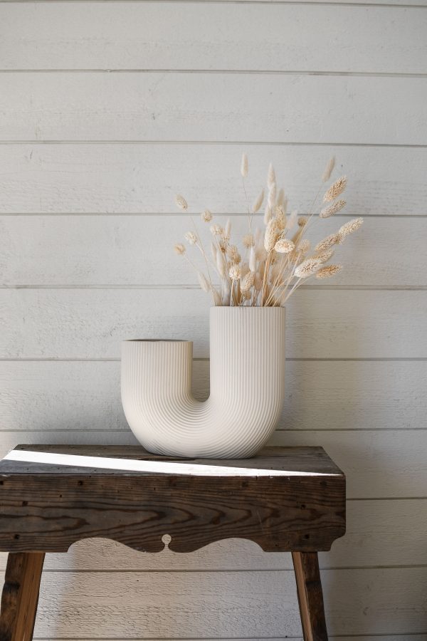 Moderná keramická váza v jednoduchom tvare U v bielej farbe.