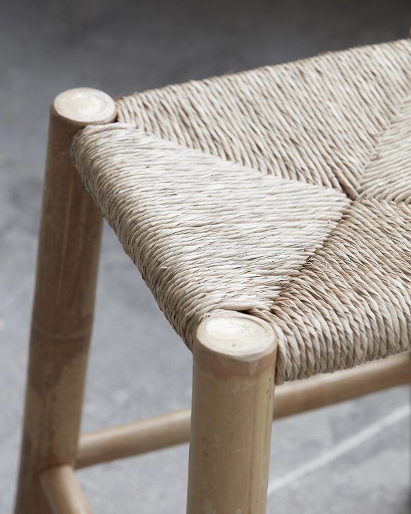 Exotická malá stolička z bambusu na štyroch nôžkach so s vypletaným sedením z morskej trávy.