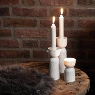 Biely porcelánový svietnik vo tvare valca so šálkou s malými uškami a vrchu, kde sa umiestňuje sviečka. Výška 15 cm.