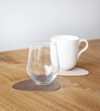 Obojstranná kožená podložka pod poháre o rozmere 13 x 11 cm.