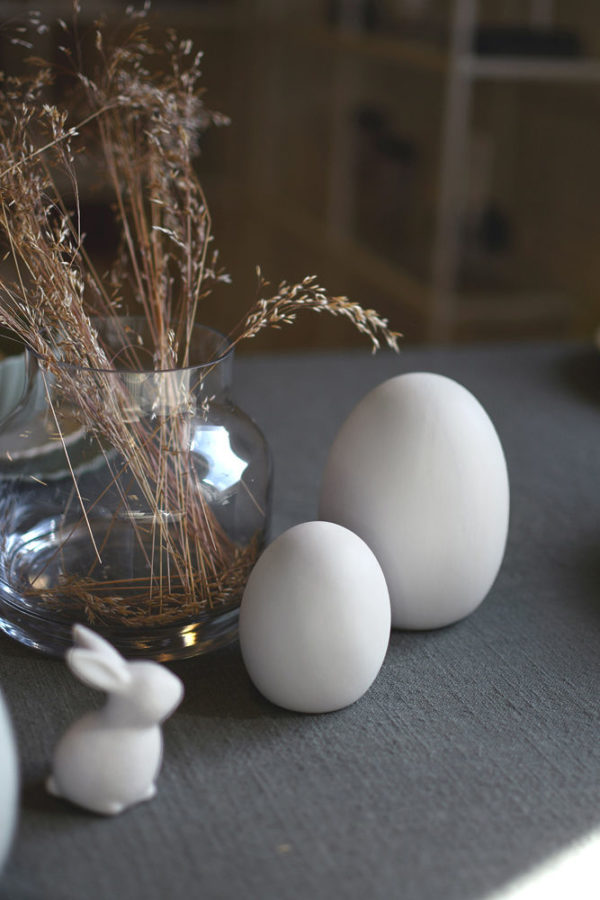 Biele keramické vajíčko s odrezanou spodnou časťou pre stabilitu o priemere 9 cm a výške 12 cm.