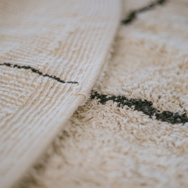 Jednoduchý a krásny okrúhly bavlnený koberec o priemere 140 cm. V bielej farbe s čiernymi pásikmi.