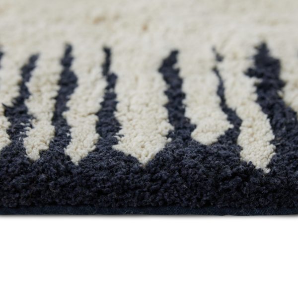 Krásny bavlnený koberec o rozmere 75 x 120 cm s čiernym podkladom a veľkým bielym vzorom v tvare bieleho obdĺžnikového slnka.